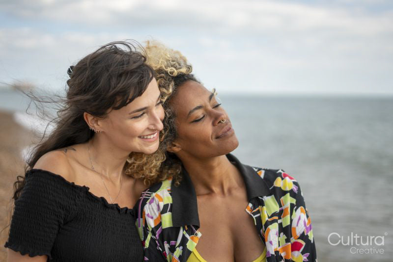 Female couple being close on beach