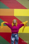 Young woman with yellow hair standing against colorful wall