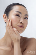 Studio portrait of woman touching face