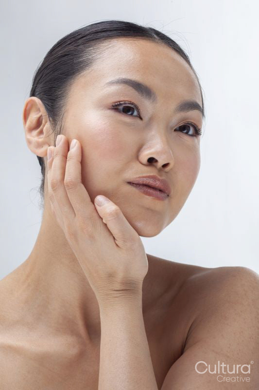 Studio portrait of woman touching face