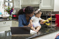 Woman working on laptop at home and taking care of baby daughter