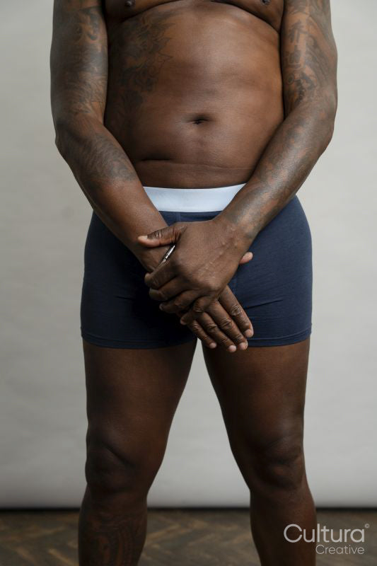 Mid section view of man wearing boxer shorts against gray background