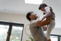 Father lifting daughter at home