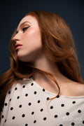 Studio portrait of a woman in a polka dot top with windswept hair