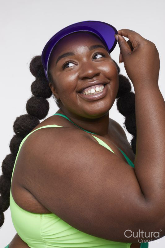 Studio shot of smiling young woman in vibrant clothing