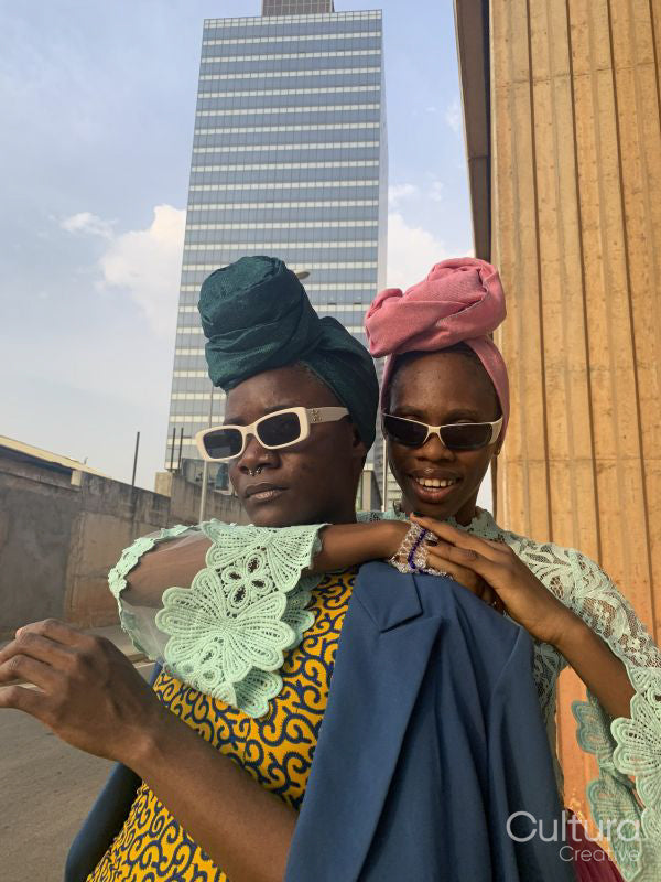 Fashion portrait of two women standing in urban street