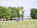 Boy dressed in uniform practicing on soccer field