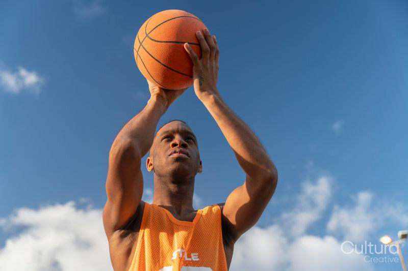 Man holding basketball ball against sky