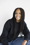 Portrait of smiling girl squatting with hand on knee on white background