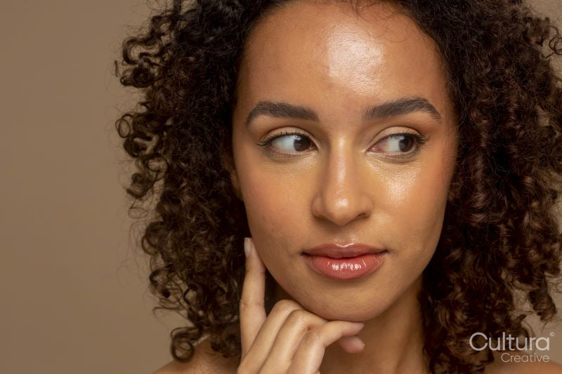 Studio shot of smiling woman with curly hair looking away