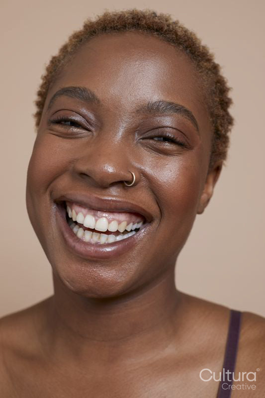 Studio portrait of smiling woman with nose ring