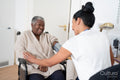 Smiling female doctor measuring senior patients blood pressure