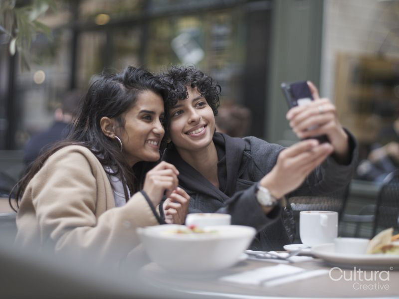 Female couple taking selfie in restaurant