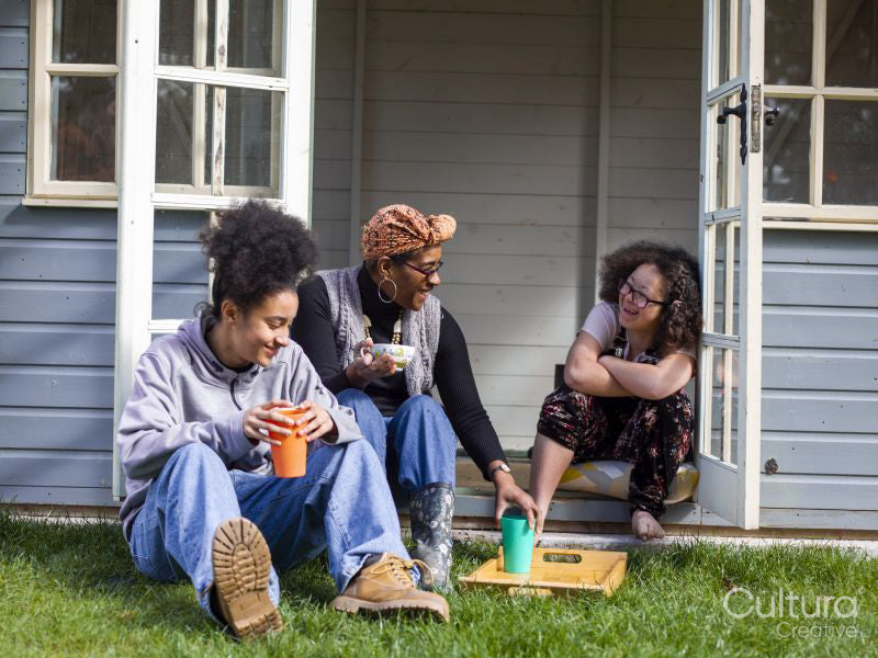 Mother with two daughters relaxing in backyard