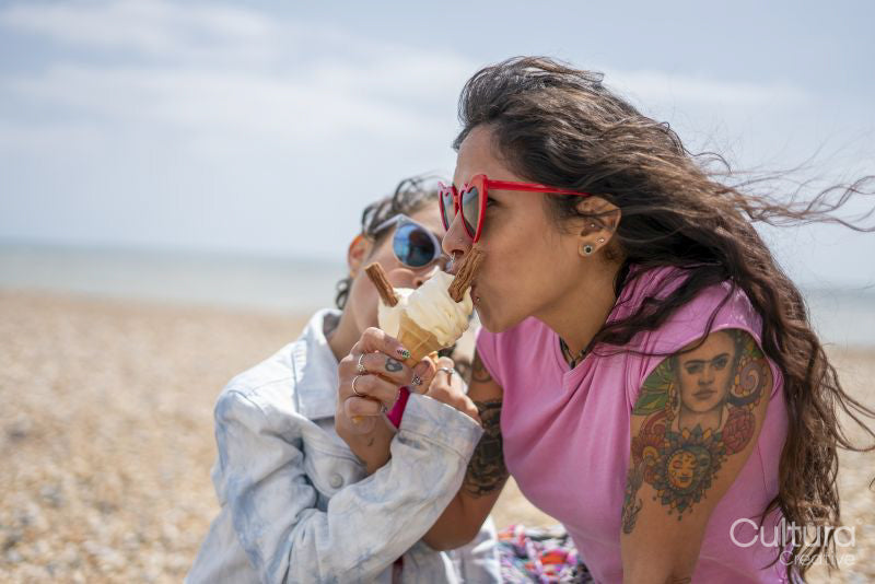 Mother and daughter eating ice cream on beach