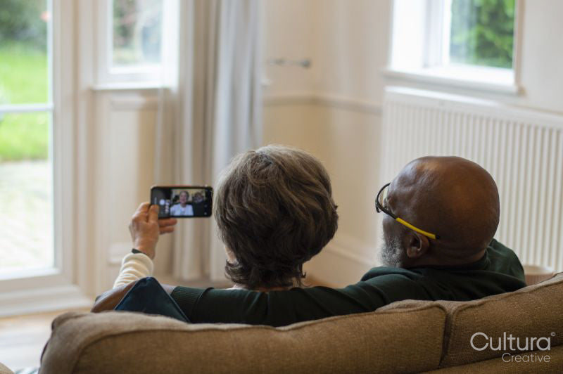 Senior couple using smart phone at home