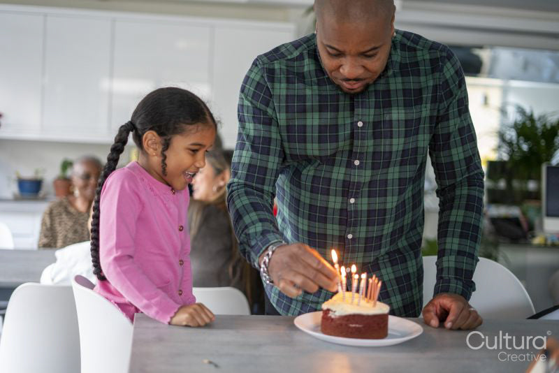 Father and daughter preparing birthday cake