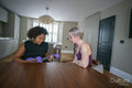 Mother assisting daughter playing ukulele at home