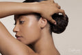 Young woman touching hair bun
