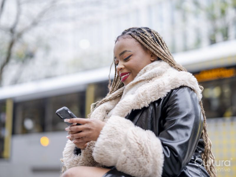 Smiling young woman using phone