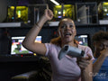 Excited woman playing video games with friend in gaming club