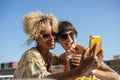 Female couple taking selfie with drinks
