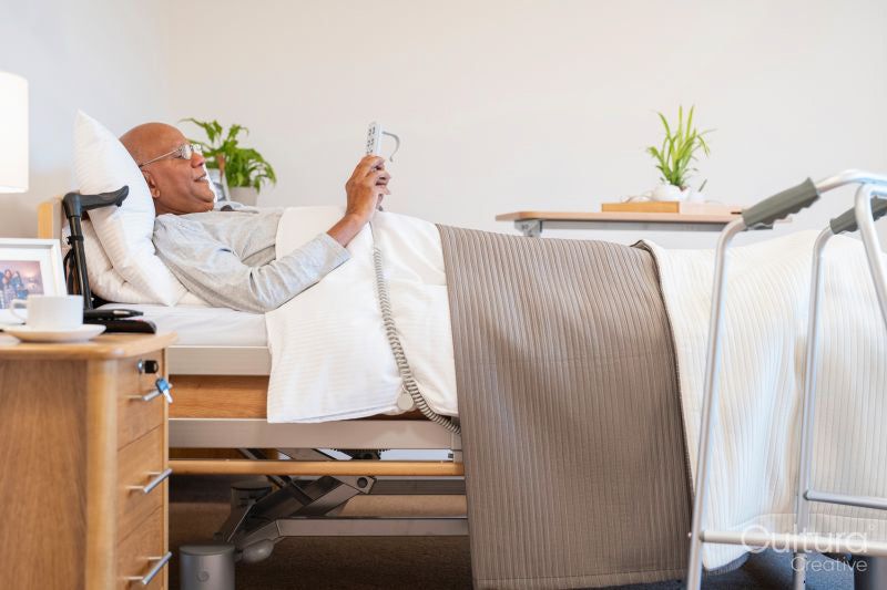 Senior man lying in adjustable bed in room at nursing home