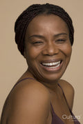Studio portrait of mature woman with braided hair laughing