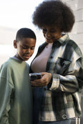 Smiling mother and son using smart phone