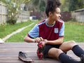 Female soccer player sitting on patio