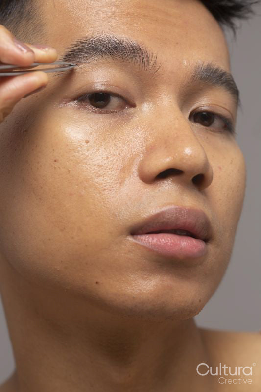 Close-up of person tweezing eyebrow