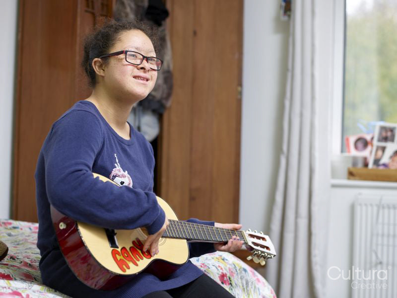 Girl with Down syndrome playing ukulele