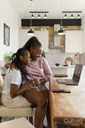 Happy couple using laptop while sitting on chair at home