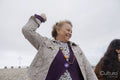 Smiling senior woman skimming stones on beach