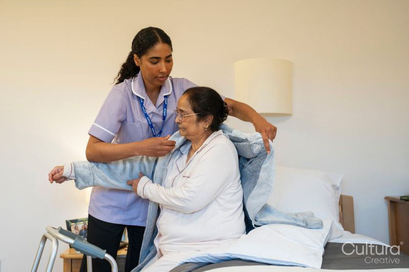 Nurse helping senior lady in her room at nursing home