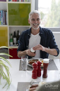 Smiling mature man eating breakfast at home