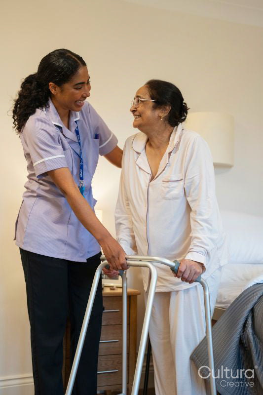 Nurse helping senior lady in her room at nursing home