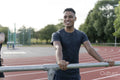 Athlete resting on railing at sports track