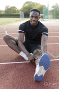 Athlete stretching legs before training at sports track