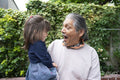 Smiling senior man with granddaughter outdoors