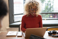 Smiling businesswoman working on laptop in office