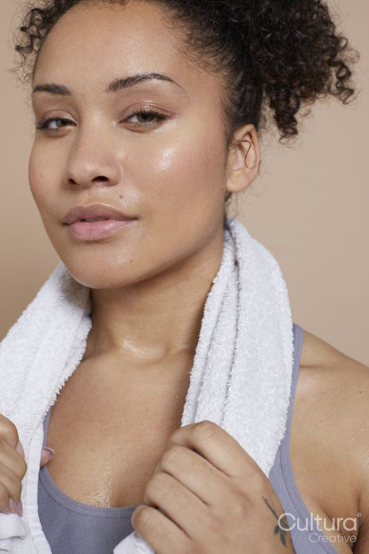 Studio portrait of athletic woman with towel around neck