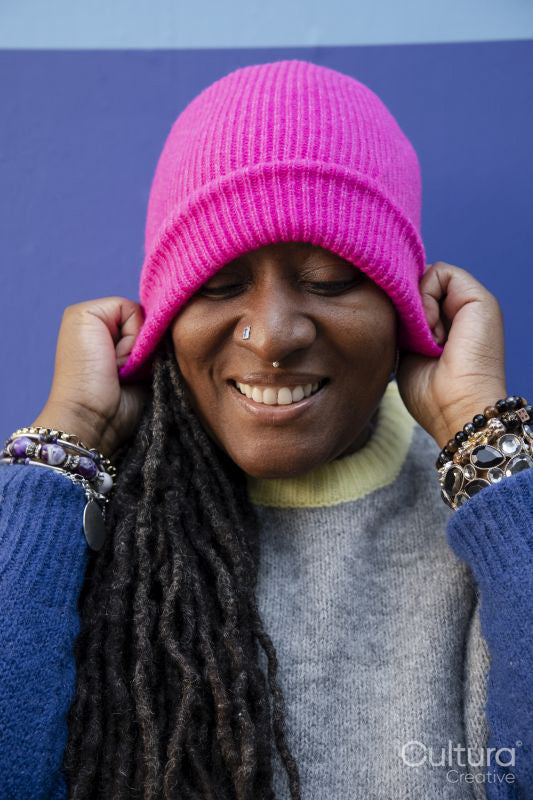 Portrait of beautiful woman putting on pink cap