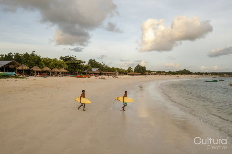 Indonesia, Lombok, Surfers entering sea at sunset