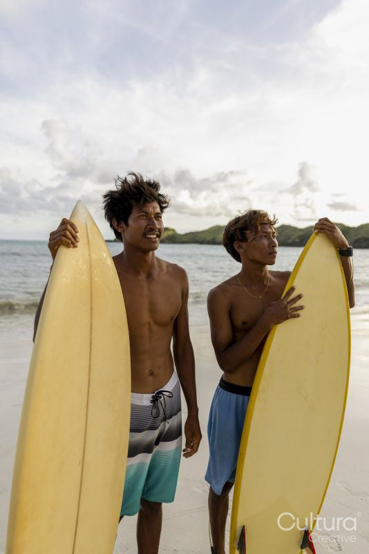 Indonesia, Lombok, Portrait of smiling surfers standing on beach