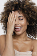 Smiling brunette woman covering face with hand