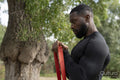 Athletic man exercising with resistance band in park