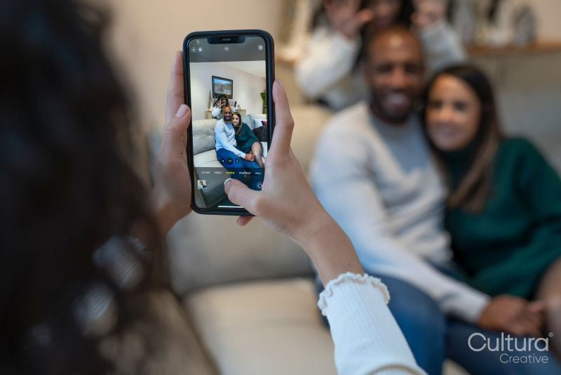 Close-up of girl photographing parents with smart phone
