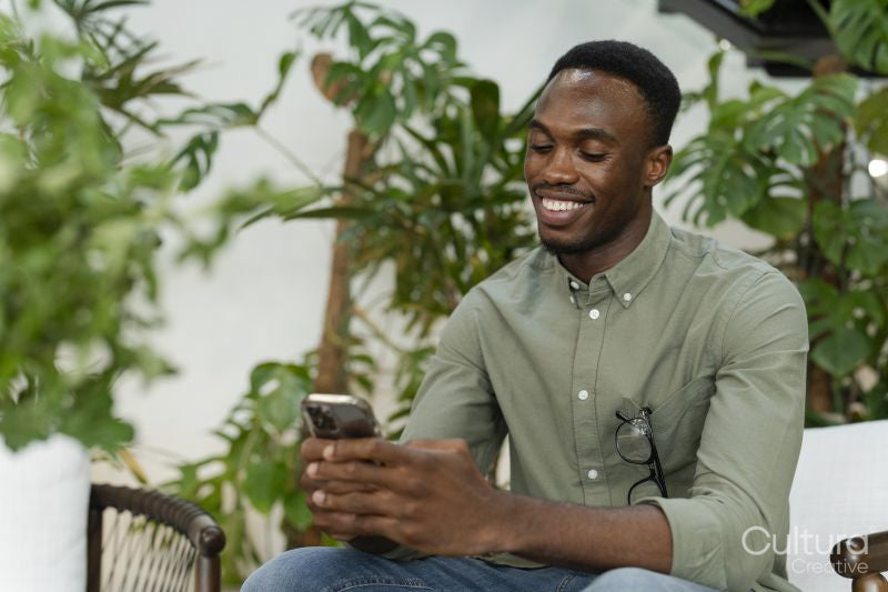 Young man with smartphone sitting in office lounge