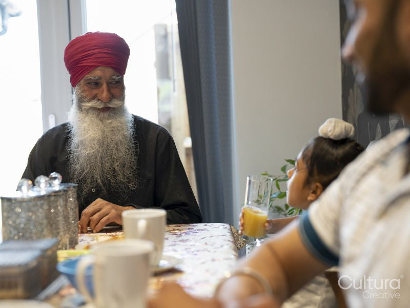 Multi-generation family sitting at table at home